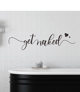 Detail of matte black Get Naked wall decal with heart accents on white bathroom tiles