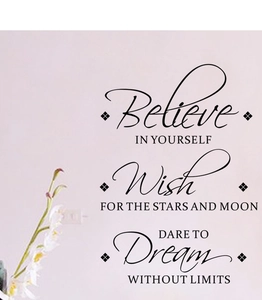 Close-up of black Believe In Yourself vinyl wall stickers on a soft purple wall