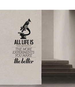 Detail of inspirational science quote wall sticker with microscope icon on a grey wall