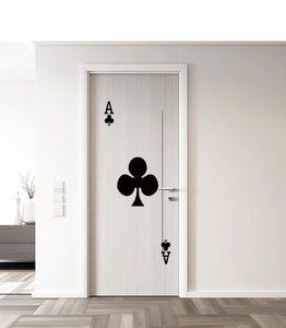 Detailed close-up of a minimalist black Ace of Clubs playing card decal on a white door