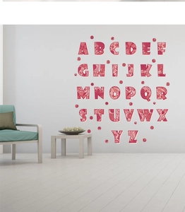 Vue détaillée de 26 stickers muraux alphabet aux motifs floraux sur un mur blanc