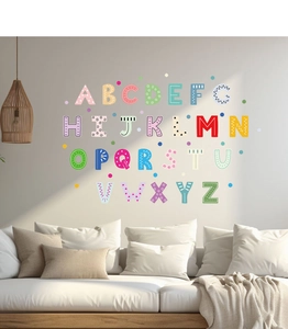 Stickers muraux 26 lettres colorées disposés au-dessus d'un canapé dans une chambre d'enfant