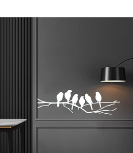 Detail of white bird and branch silhouette wall decals on a dark textured background