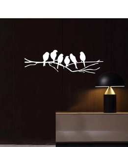 Detail of white bird silhouettes on branch wall decal against a dark wood texture wall
