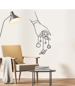 Creative wall decal featuring a hand holding planets and stars in minimalist black line art