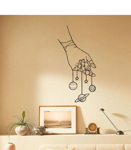 Minimalist black line art wall sticker showing a hand holding planets for home decor