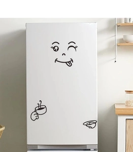 Close-up of funny DIY emoji fridge stickers with winking face on white refrigerator