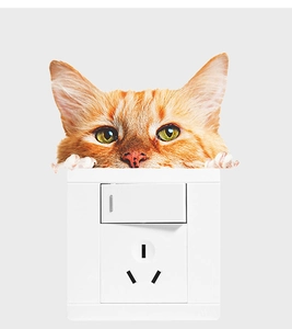 Detailed view of a 3D orange tabby cat sticker peeking over a white wall switch socket