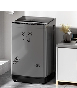 Close-up of funny cartoon winking face sticker on a grey washing machine panel