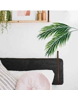 Détail de stickers muraux feuilles de palmier tropical sur un mur blanc de chambre