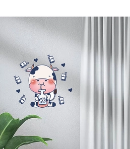 Close-up of a cartoon cow and milk box wall sticker in a cozy home interior setting