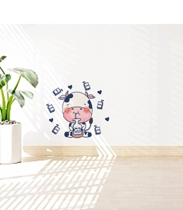 Detail view of cute cartoon cow wall sticker with milk bottle on a white wall