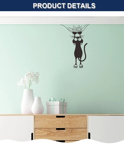 Detail of funny climbing black cat wall sticker with vivid eyes on a green wall background