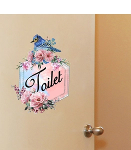 Sticker mural fleuri avec oiseau bleu et signe Toilet sur surface de porte en bois clair