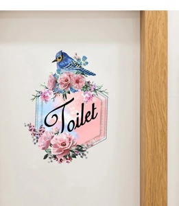 Détail d'un sticker mural fleuri avec oiseau bleu et texte Toilet sur un mur blanc pur