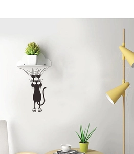 Creative black cartoon cat wall sticker showing a funny climbing pose in a cozy home decor setting