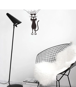 Funny black cat wall sticker scratching down on a white wall in modern home decor