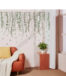 Realistic green leaf vine wall stickers displayed above a cozy sofa in a living room