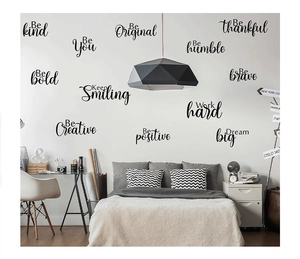 Close-up of 12 sets of black inspirational letter wall decals in a modern bedroom setting