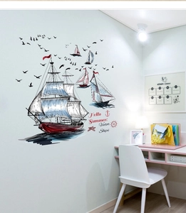 Detail view of vintage sailboat and seagull wall decals in a cozy bedroom setting