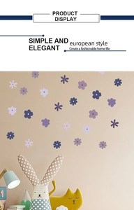 Detail of colorful purple flower wall stickers in a cozy nursery room setting with a lamp