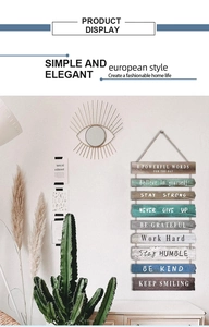 Détail d'une plaque suspendue en bois inspirante avec panneaux colorés sur mur blanc