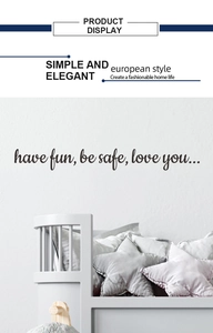 Detail of removable black vinyl wall decal with have fun be safe love you text on white wall