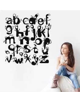 Nursery scene showing black cartoon monster alphabet wall decals for kids' rooms