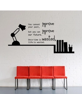 Détail d'un sticker mural avec citation inspirante noire sur un mur de briques blanc