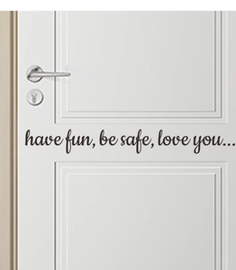Detail of 'have fun, be safe, love you' black vinyl wall decal on a white wooden door