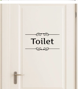 Sticker de porte de toilette noir minimaliste avec motifs floraux sur une porte blanche