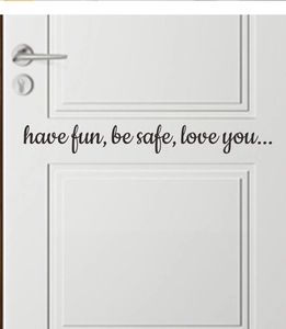 Detail of cursive wall decal with text 'have fun, be safe, love you' on a white door