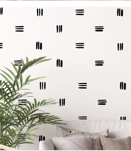 Stickers muraux minimalistes noirs en PVC présentés dans un décor de salon chaleureux