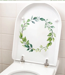 Close-up of watercolor green leaf floral wreath decal on a white toilet lid