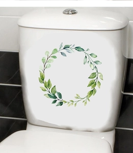 Detail view of watercolor green leaf wreath sticker on a white ceramic toilet tank