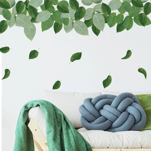 Self-adhesive minimalist green leaf wall decals for home decor above white sofa