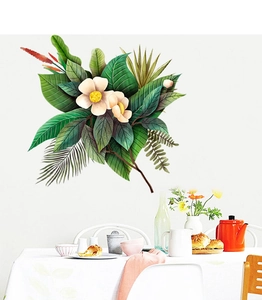 Dettaglio di adesivi murali con foglie tropicali e fiori bianchi su parete bianca
