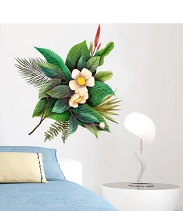 Dettaglio di adesivi murali con foglie di palma tropicali e fiori su una parete bianca