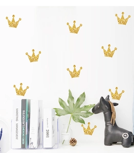 Close-up of golden glitter crown wall stickers in a modern minimalist nursery room decor