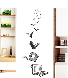 Artistic detail of black bird wall decal rising from open book in a modern living room