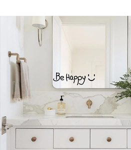 Detail of Be Happy vinyl wall decal on a bathroom mirror with minimalist decor