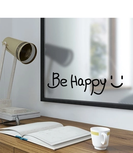 Detail of 'Be Happy' wall sticker with smiley face on a mirror in a cozy home office