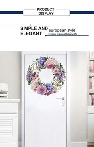 Detail showing hand-painted pink and purple floral wreath wall decal on a white door