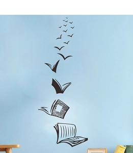 Creative wall sticker showing books transforming into flying birds on a blue wall