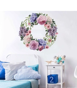 Detail of hand-painted watercolor peony wreath wall decal in a cozy bedroom setting