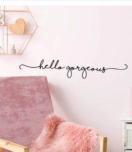 Close-up of hello gorgeous hand-drawn black wall sticker on a soft pink bedroom wall
