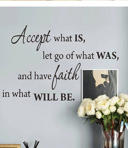 Dettaglio dell'adesivo murale con citazione ispiratrice 'Accept what IS' in un arredamento moderno