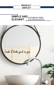 Détail d'un miroir mural rond avec sticker lettrage smile it looks good on you