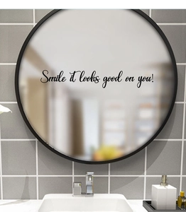 Détail du miroir décoratif rond avec l'inscription artistique Smile it looks good on you