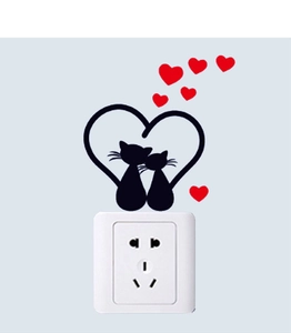 Detail of cartoon couple black cat silhouettes with red hearts on a white light switch